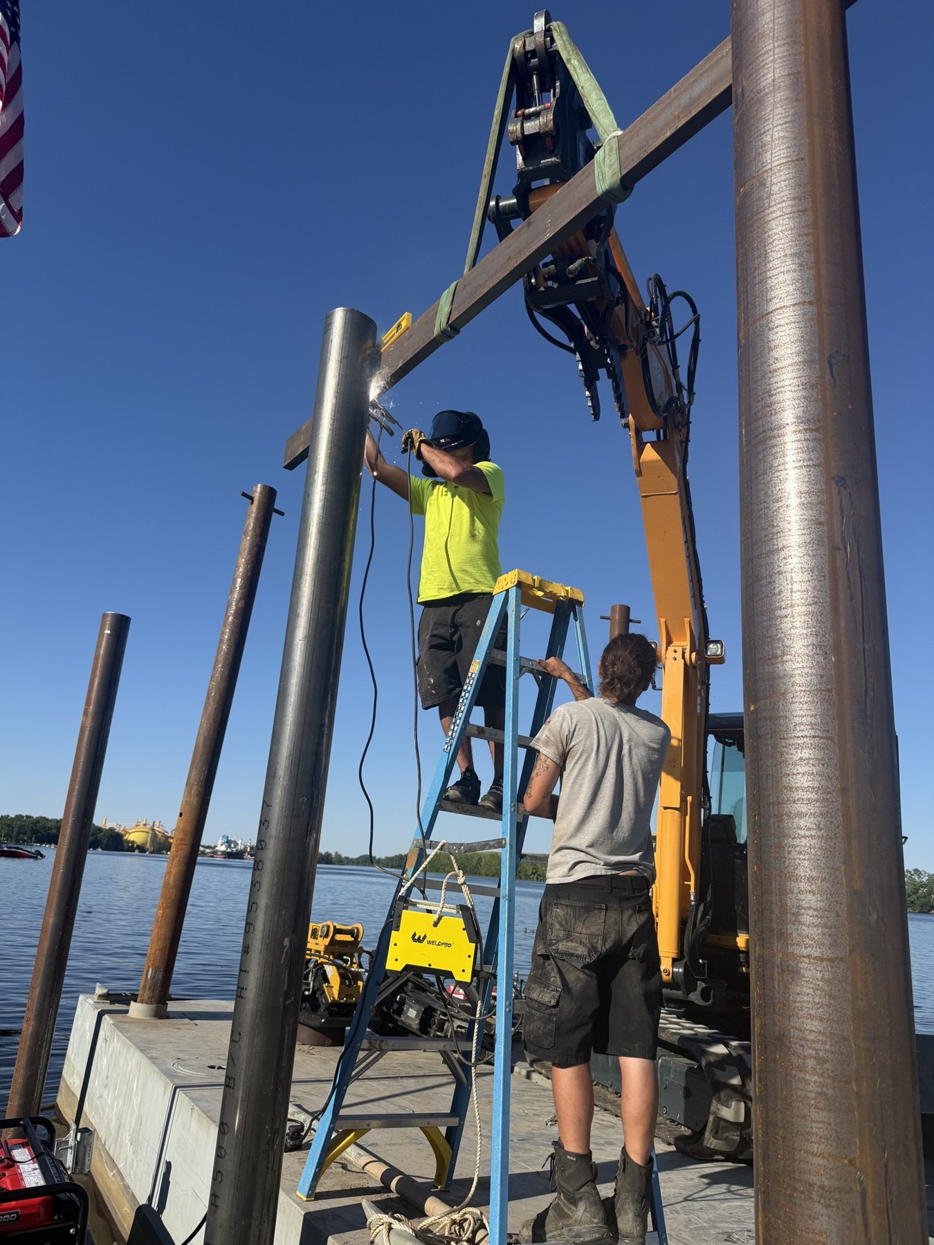 Crew welding a steel pipe pile on the barge deck